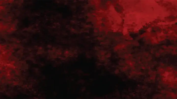 A blotchy dark surface under red light